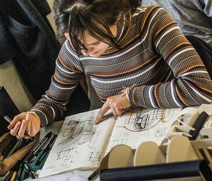 Étudiante en design à l'École Bleue travaillant sur des croquis