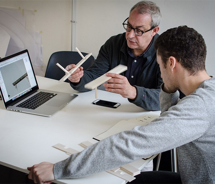 Professeur et étudiant discutant d'une maquette en classe à l'École Bleue