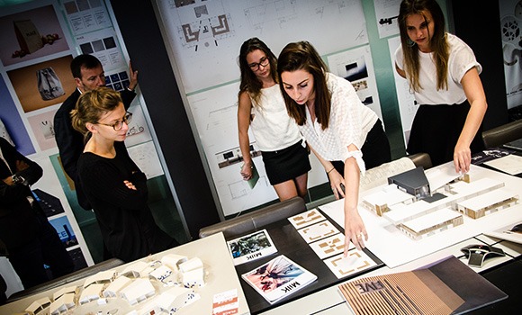 Étudiantes de l'École Bleue présentant un projet d'architecture avec maquettes